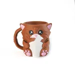 A Brown Cat And Two Spoons